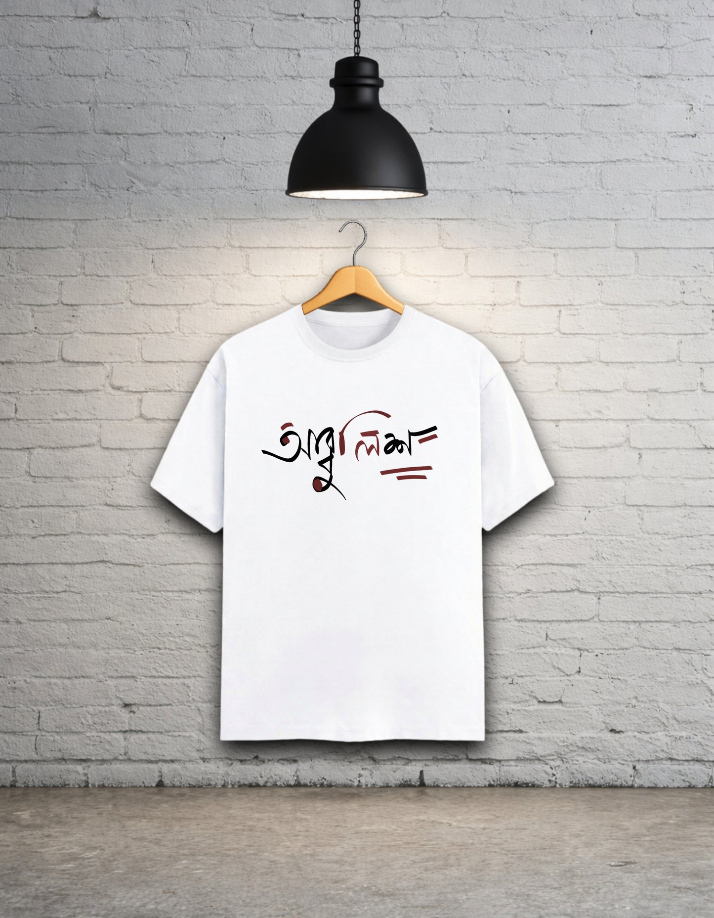 White t-shirt with text design 'Abbuleesh' on a wooden hanger against a white brick wall.