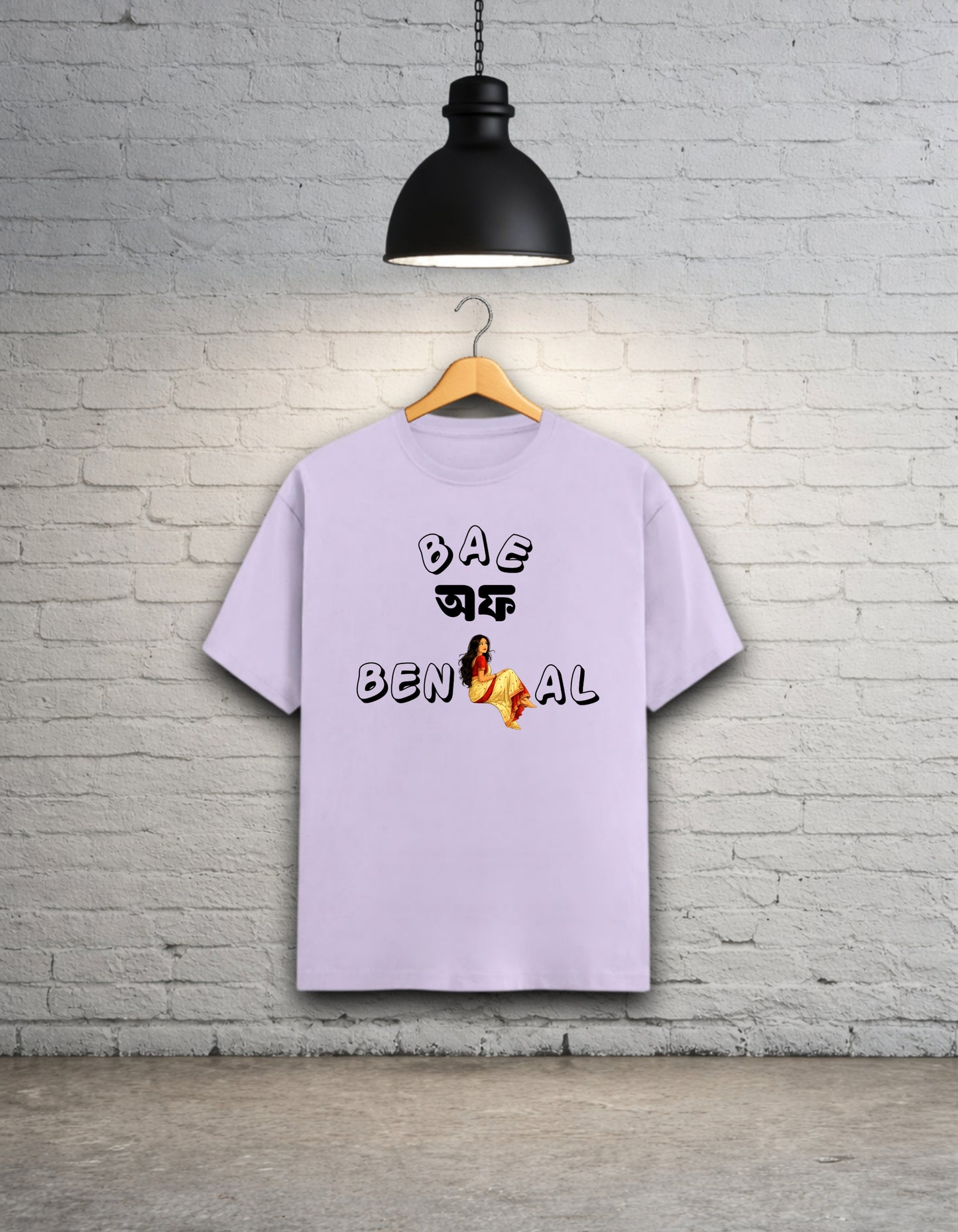 Lavender t-shirt written 'Bae of Bengal' graphics on a hanger against a brick wall.