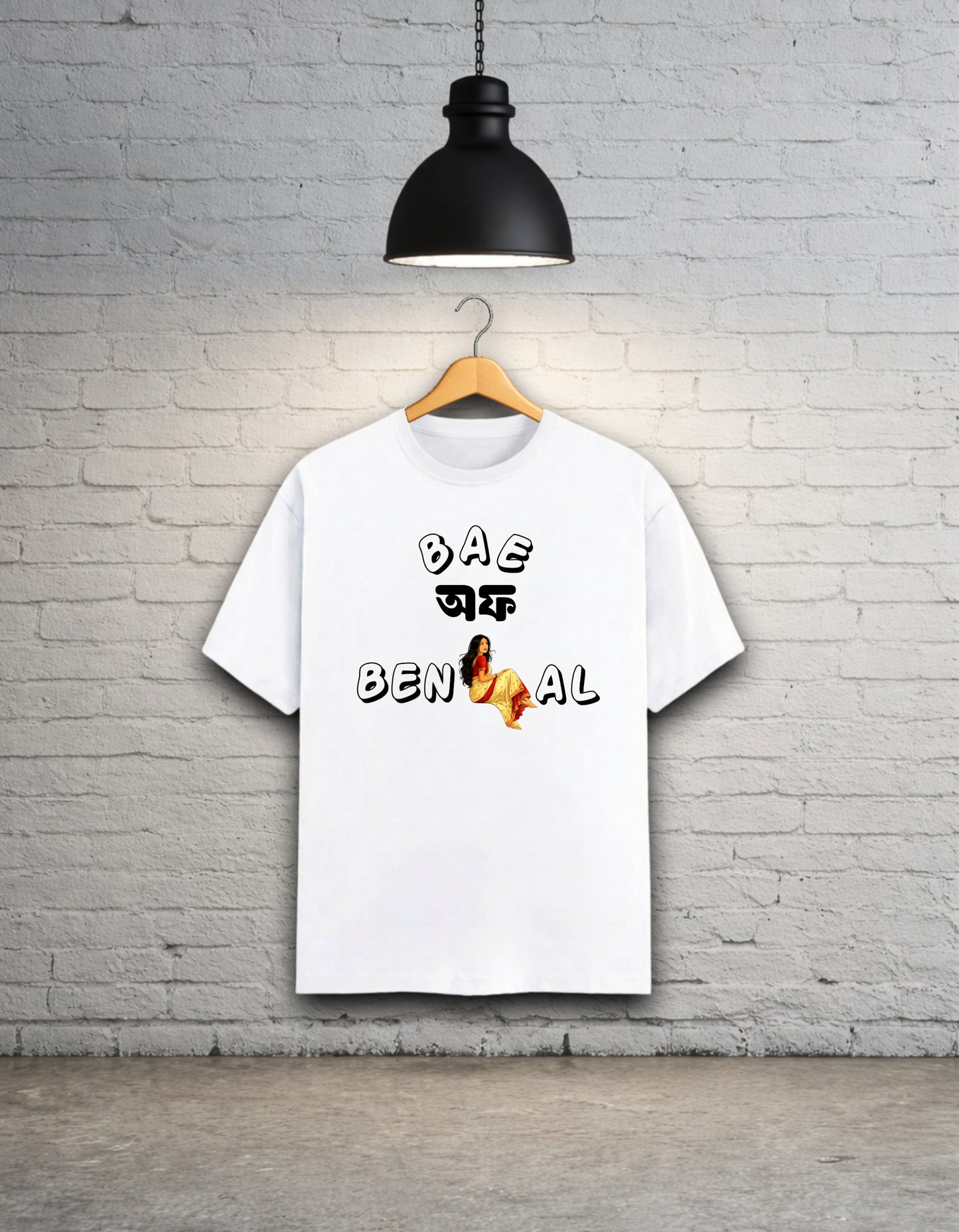 White t-shirt written 'Bae of Bengal' graphics on a hanger against a brick wall.