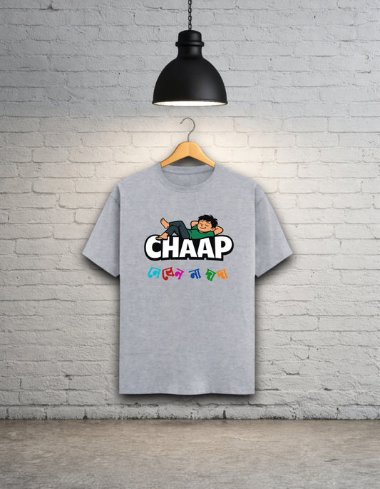 Grey t-shirt with 'CHAAP nebenna dada' bengali graphic design hanging on a brick wall.