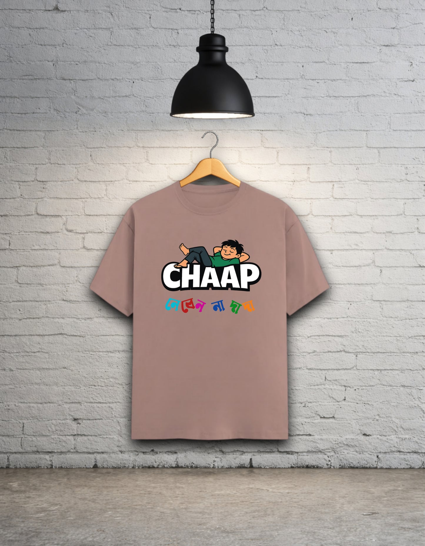 Mushroom t-shirt with 'CHAAP nebenna dada' bengali graphic design hanging on a brick wall.